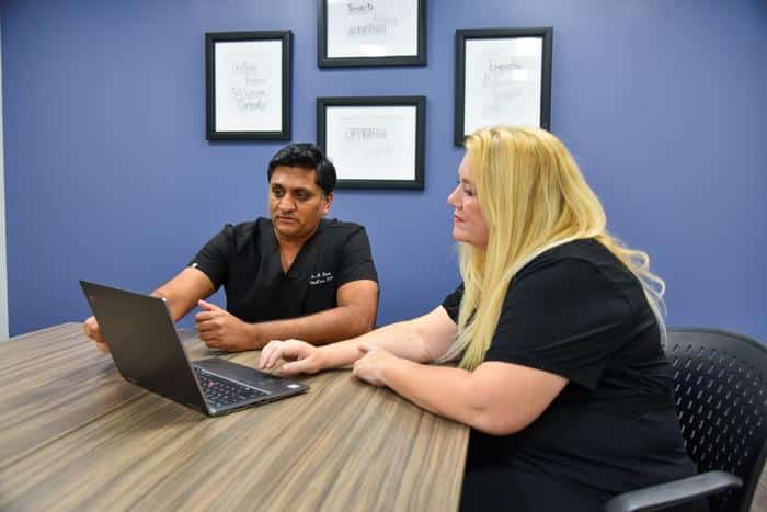 Katie nunn sitting at table using computer to contact medical practices and work